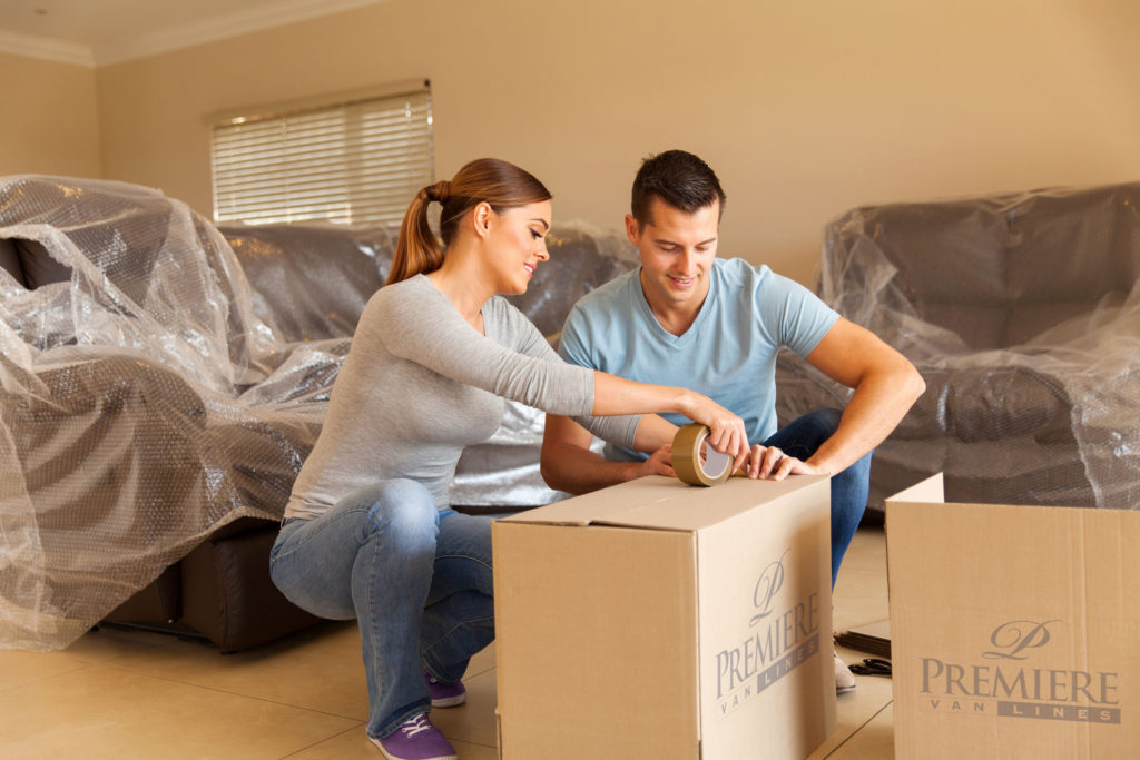 Two people packing a box
