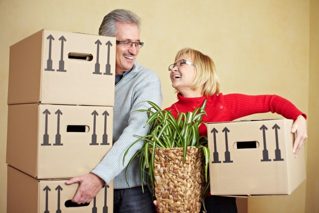 Couple holding moving boxes