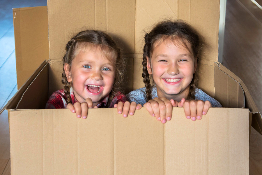 Smiling children look out of a box